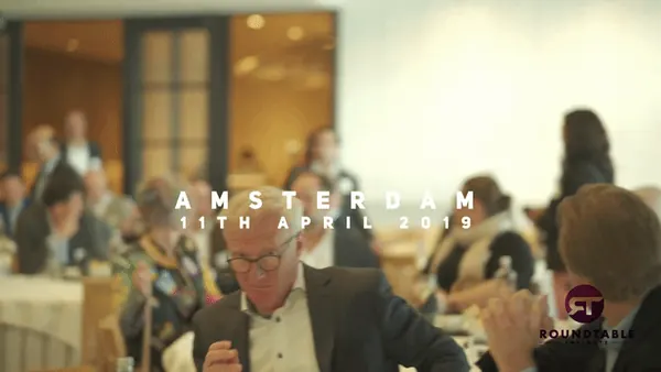 Roundtable Insights event: conference guests at round tables in a bright hall in Amsterdam