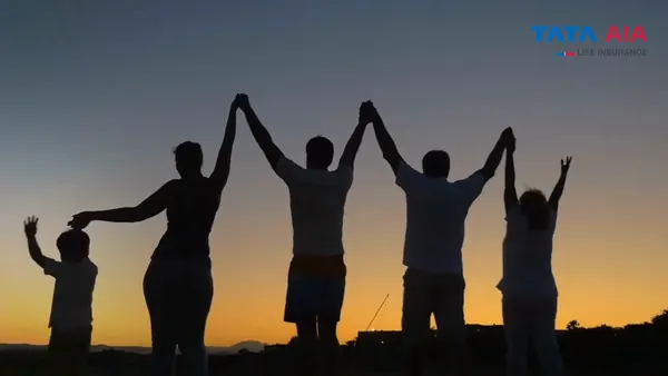 TATA AIA Life Insurance campaign film: silhouettes of people raising joined hands against an orange sunset